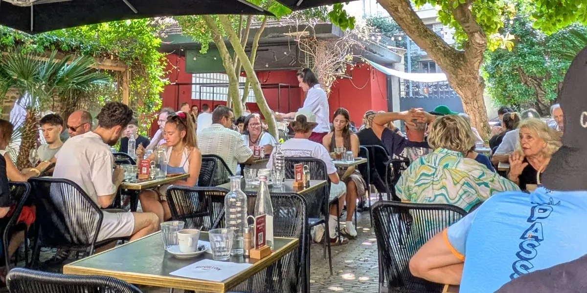 Terrasse arborée et ombragée du Bouillon Liberté à Rennes, tables occupées sous les parasols un midi d'été