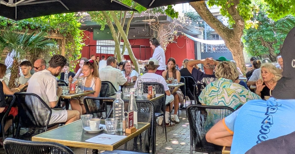 Terrasse arborée et ombragée du Bouillon Liberté à Rennes, tables occupées sous les parasols un midi d'été